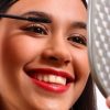 Les sourcils, un business des plus rentables Happy Young Teenager Using A Mirror Making Herself Up Using Mascara